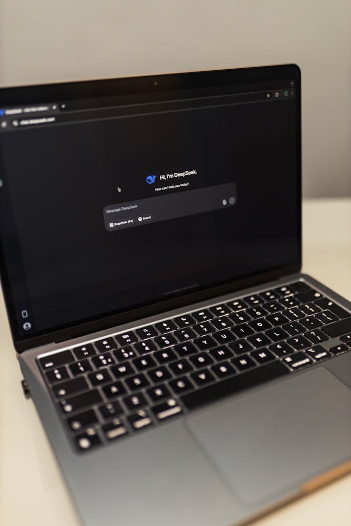services-03 Close-up of a laptop showing an AI chat interface in a dimly lit room.