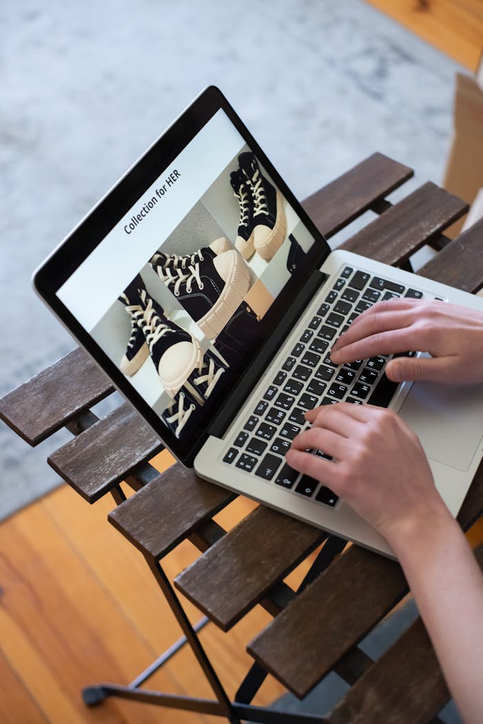 our-story Hands browsing sneakers on laptop, showcasing online store shopping experience.
